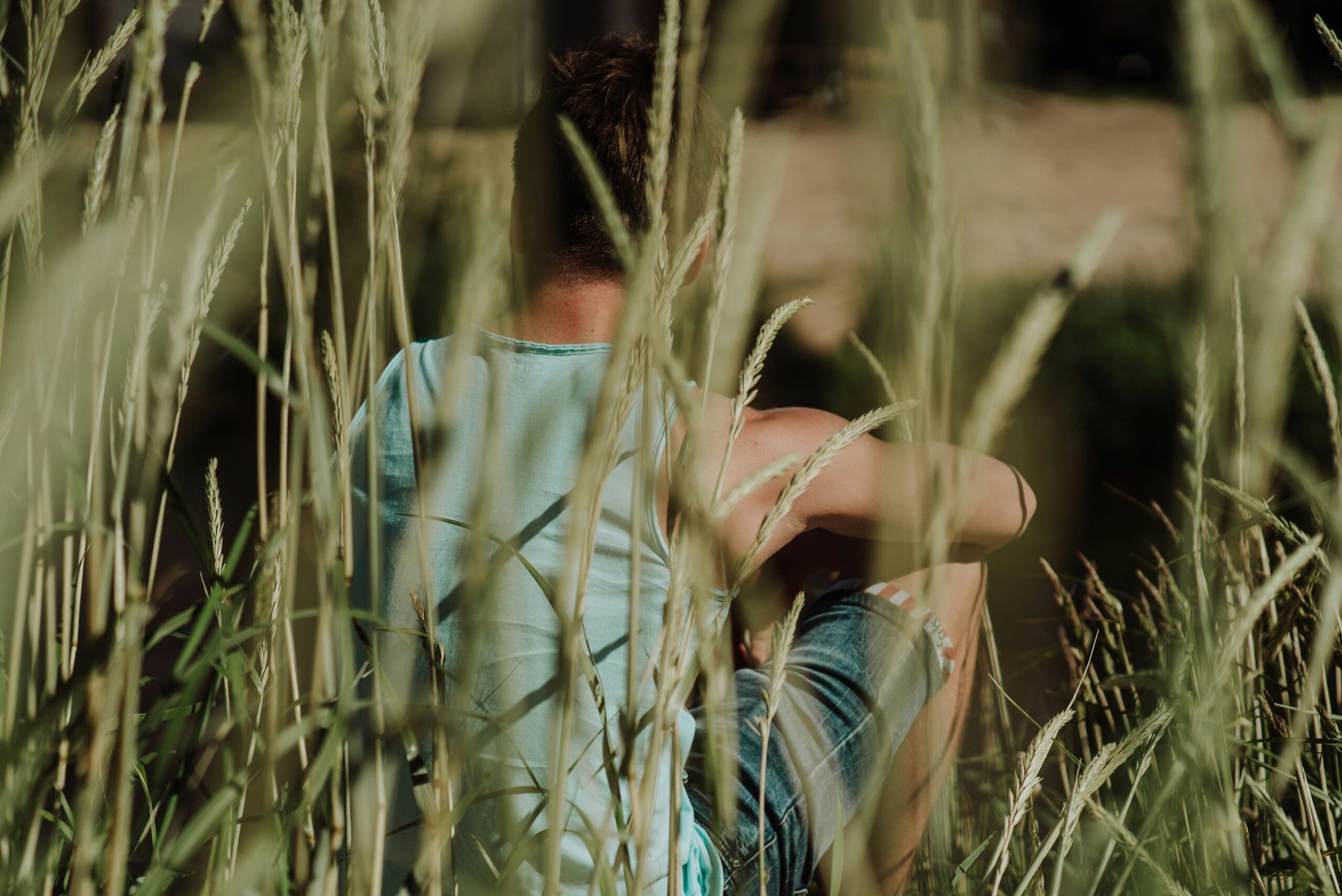 Man sat in the reeds by the side of the river
